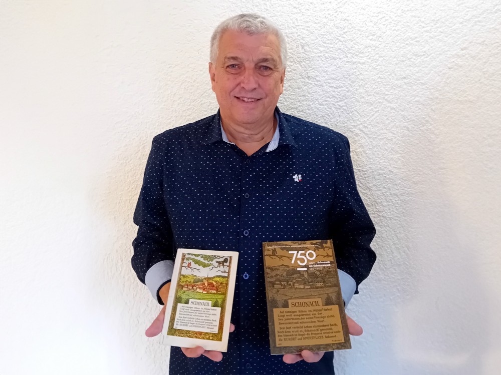 Wolfgang Schyle mit der Erstauflage und der Neuauflage der Chronik
