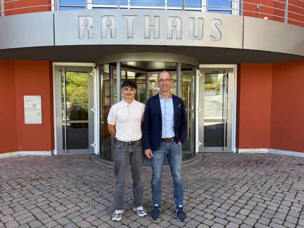 Bürgermeister Jörg Frey mit dem neuen Auszubildenden Justin Scungio vor dem Rathaus Schonach